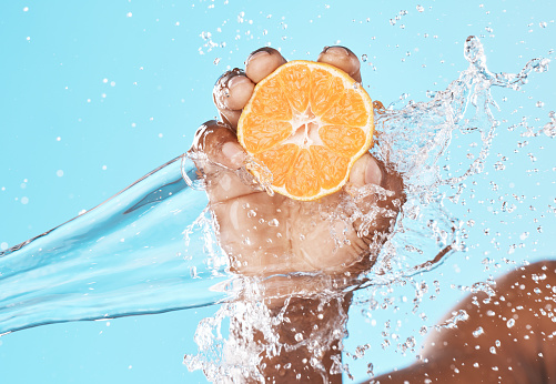 Water splash, lemon in hand and studio background for healthy, vegan and nutrition food on advertising, marketing or promotion mockup. African, shower and vitamin c, fruit benefits in clean skincare