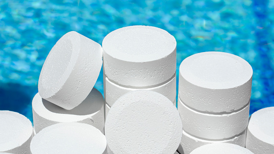 Tableta de cloro para piscinas. Productos químicos para el mantenimiento de piscinas en forma de tabletas redondas para mantener el agua y el pH limpios mediante la adición de cloro a las piscinas. photo