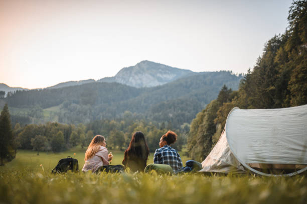 istock Female Hikers Sitting on the Grassy Slope 1473234555