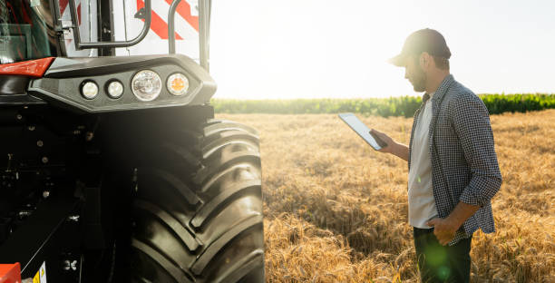 istock Farmer with digital tablet on a background of harvester. 1473234670