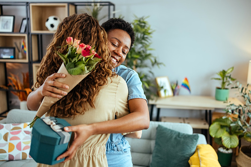 Woman surprises her girlfriend with a gift and flowers