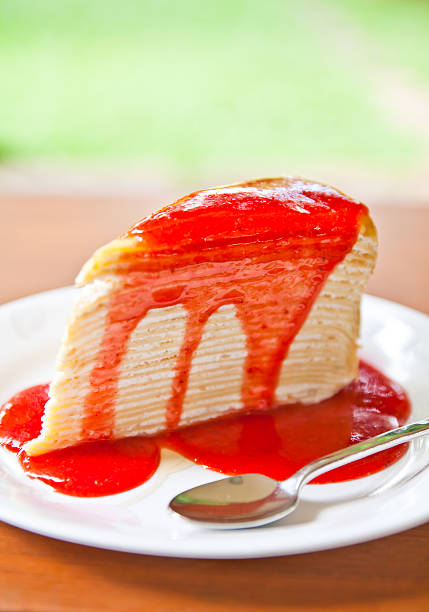 Crepe cake with strawberry sauce stock photo