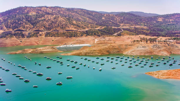 A serene and tranquil lake is beautifully surrounded by majestic mountains under a clear blue sky above