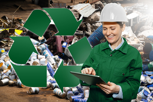A worker with a digital tablet at a waste recycling plant. Waste management concept