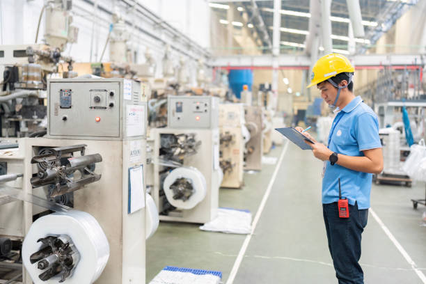 istock Asian male engineer in plastic industry factory Checking inventory, planning business projects in warehouse And there are machines working around it. Wear uniforms and helmets. 1473238731