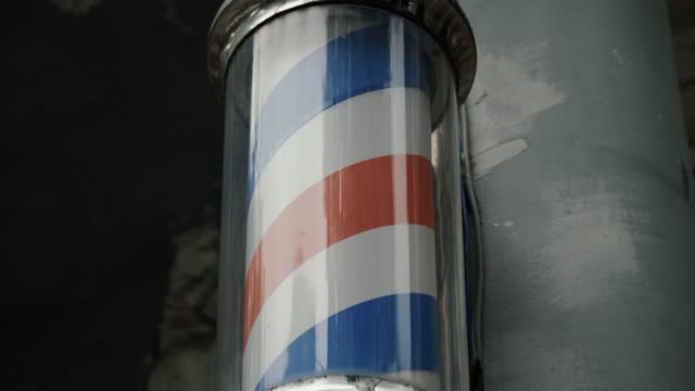 Rotating barbershop pole close up. Logo of barber shop, symbol in retro style