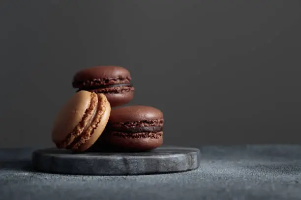 Chocolate eco handmade natural macaroons on dark background in the darkmood style. Horizontal banner top view with a copyspace