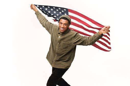 Cheerful African-American guy holding in hands american flag and running isolated over white background, multiracial foreign student man holding US flag, independence day celebration, holiday