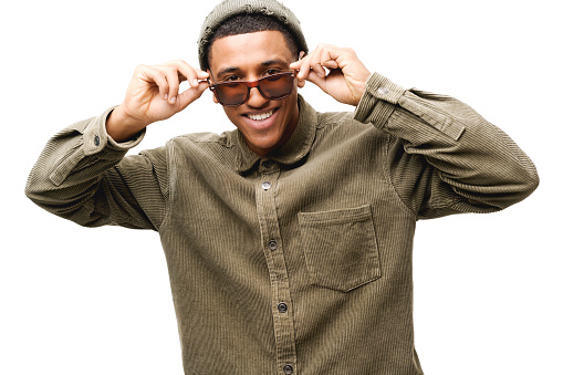 Stylish handsome african-american young man wearing casual shirt, hat and sunglasses has good mood, posing isolated on white background, attractive guy flirting