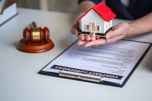 Close up of unrecognizable agent showing his customers where to sign a contract.