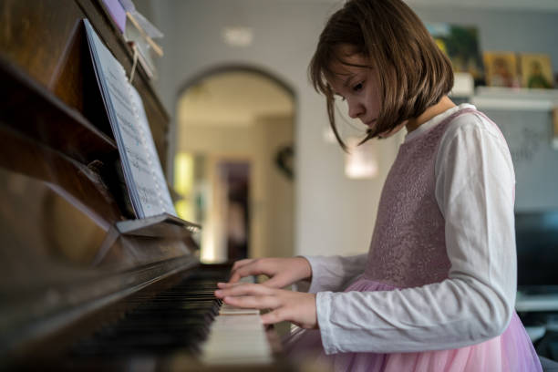 istock Cute girl playing piano at home 1473252557