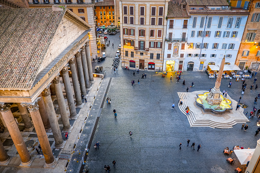 Rome, Italy, October 22 -- A very suggestive evening scene of the majestic colonnade of the Roman Pantheon and Piazza della Rotonda seen from a terrace in the historic heart of Rome. Built in 27 BC by the Consul Marco Vispanio Agrippa for the emperor Augustus and dedicated to the Roman divinities, the majestic Pantheon is one of the best preserved Roman structures in the world. The fountain with the Egyptian obelisk in the center of the square was built by the sculptor Leonardo Sormani in 1575 on a project by the architect Giacomo della Porta. In 1980 the historic center of Rome was declared a World Heritage Site by Unesco. Wide angle image in high definition quality.