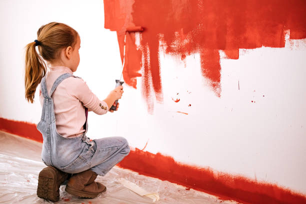 istock Little girl painting a wall red 1473255592