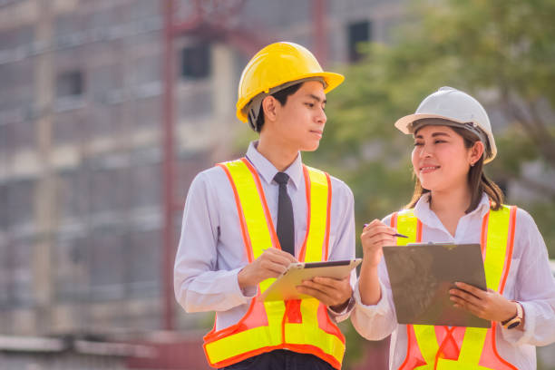istock Male and female Engineer standing talking about construction project background 1473256265