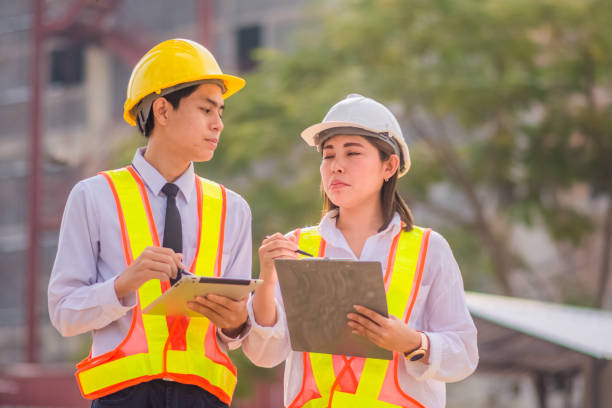 istock Male and female Engineer standing talking about construction project background 1473256288