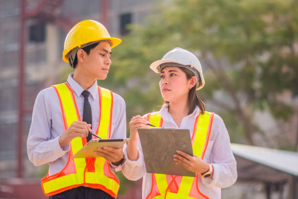 istock Male and female Engineer standing talking about construction project background 1473256294