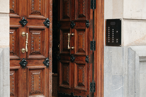 Elegant wooden double front door with curved top, surrounded by flowers