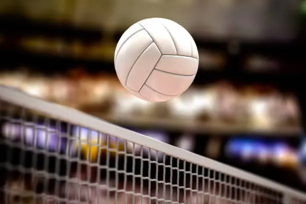 Photo of Volleyball ball and net in voleyball arena during a match.