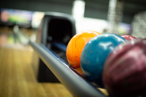 Multicolored balls in the bowling alley on rack