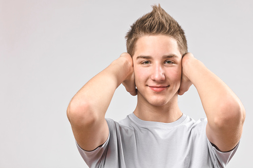 Teenage boy covering his ears