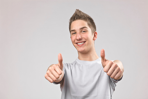 Happy teenage boy showing thumb up