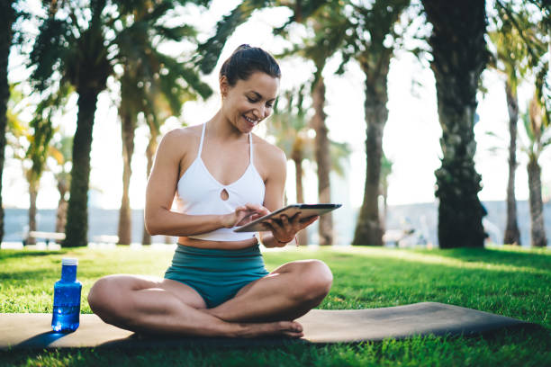 istock Happy sports woman enjoying touch pad messaging with trainer using 4g internet connection during morning time for park workout, cheerful female athlete in tracksuit watching online fitness video 1473265465