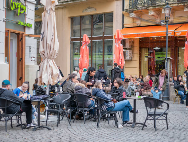 Urban scene with people sitting at tables and having a drink in the old town center of Bucharest Bucharest, Romania - March 2023: Urban scene with people sitting at tables and having a drink in the old town center of Bucharest bucharest people stock pictures, royalty-free photos & images