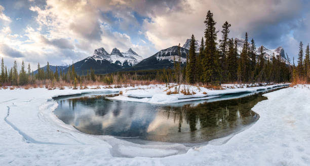 istock Panorama view of Three Sisters Mountains with snow covered on bow river reflection in the morning on winter at Canmore 1473271658