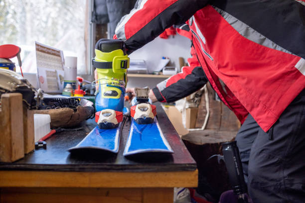 o assistente de aluguel de esqui ajusta esquis a botas de esqui. - skiing ski boot rental equipment - fotografias e filmes do acervo