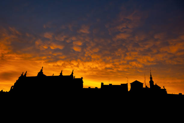 Solid blue sky on a cityscape dark silhouettes and sun shining