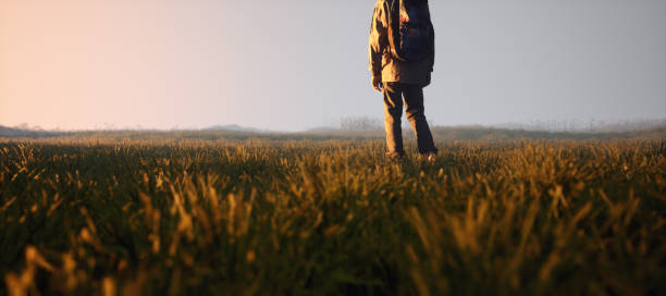 istock Boy with backpack in pasture in countryside during sunset. 3D rendering. 1473282733