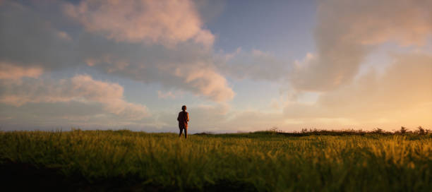 istock Girl with backpack in pasture in countryside under a blue cloudy sky during sunset. 3D rendering. 1473282763