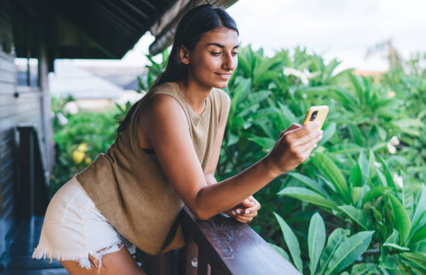 istock Smiling ethnic woman messaging on smartphone 1473286513