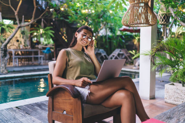 istock Joyful ethnic woman browsing laptop on terrace 1473286685