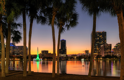 Orlando city skyline at sunset in Lake Eola Park with fountain and cityscape, Florida, USA.