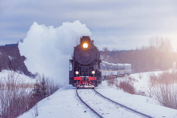 istock Retro steam train moves at winter evening. 1473289769