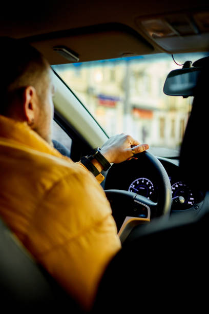 istock Concentrated bearded man in casual clothes driving modern car 1473295172