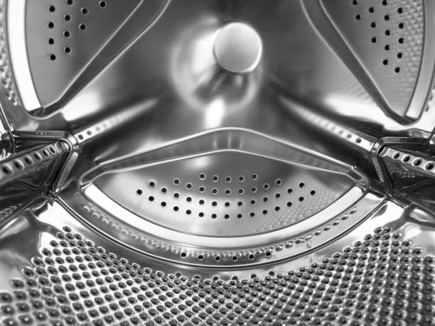 istock Washing machine drum close up. Washing machine background. Inside the washing machine. Metal washing machine drum. Perforated shiny metal 1473297379