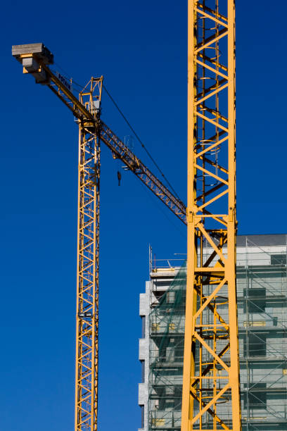 istock Scaffolding in a construction site of a tall building. Construction cranes. 1473297400