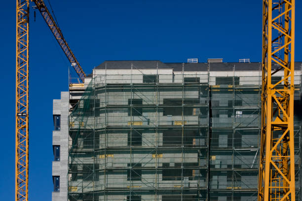 istock Scaffolding in a construction site of a tall building. Construction cranes. 1473297419