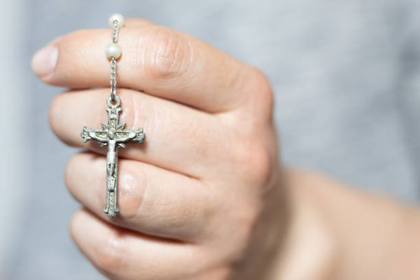 istock Close up of a white hand holding a silver rosary 1473299806
