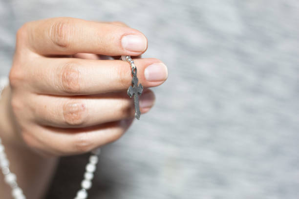 istock A white hand holding a rosary 1473299808