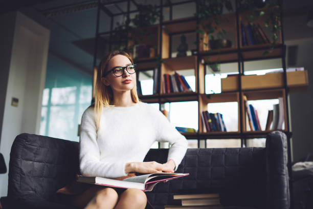 istock Thoughtful female sitting in library with books 1473304623