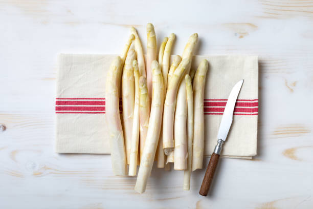 Bunch of raw white asparagus on white wooden table. Top view, copy space stock photo