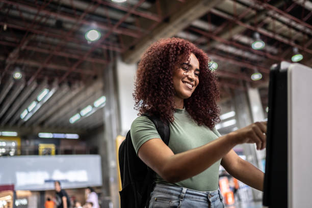 istock Young woman doing self service check-in at the airport 1473306740