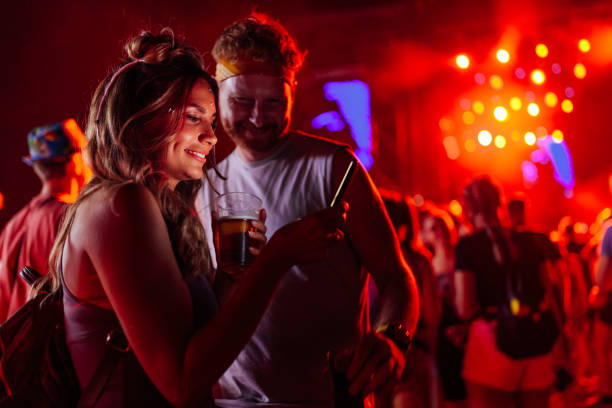 istock Couple using smartphone at festival 1473307111