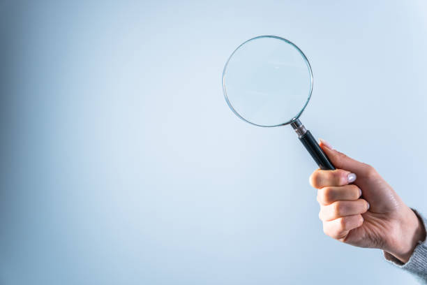 istock Young woman holding magnifying glass 1473307533