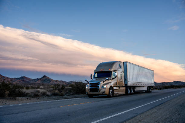 istock A Semi-Truck on a Two-Lane Highway with Beautiful Clouds at Sunset 1473307929