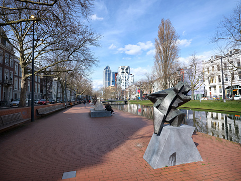 rotterdam, netherlands, 13 march 2023: modern art along canal in centre of dutch city rotterdam under blue sky early spring
