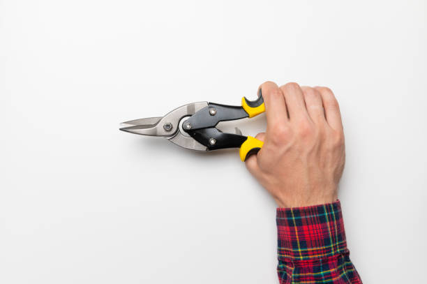 hand of a male craftsman firmly hold a construction tool on a white background, a template for a banner stock photo
